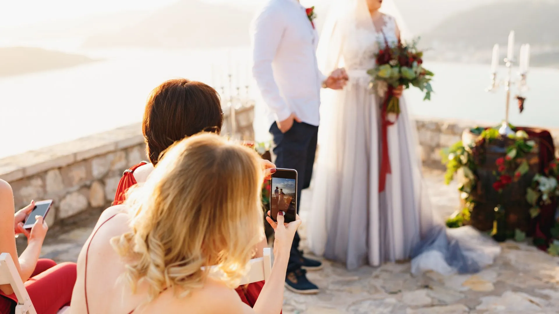 Wedding guest photographing the ceremony to share with the couple